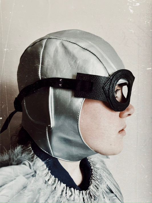 Side view of a child wearing a vintage flying costume