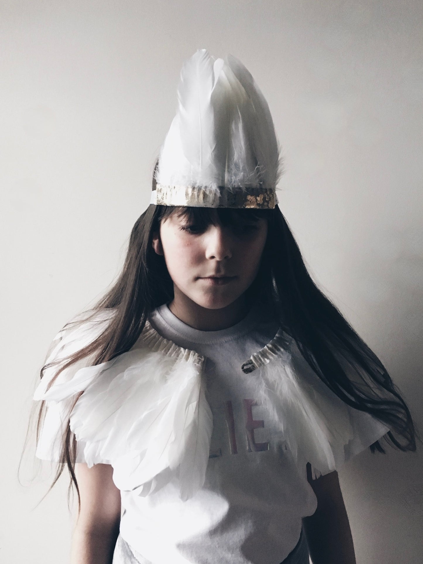 girl with long dark hair, wearing a white feather cape and headdress by For Just ONE Day 