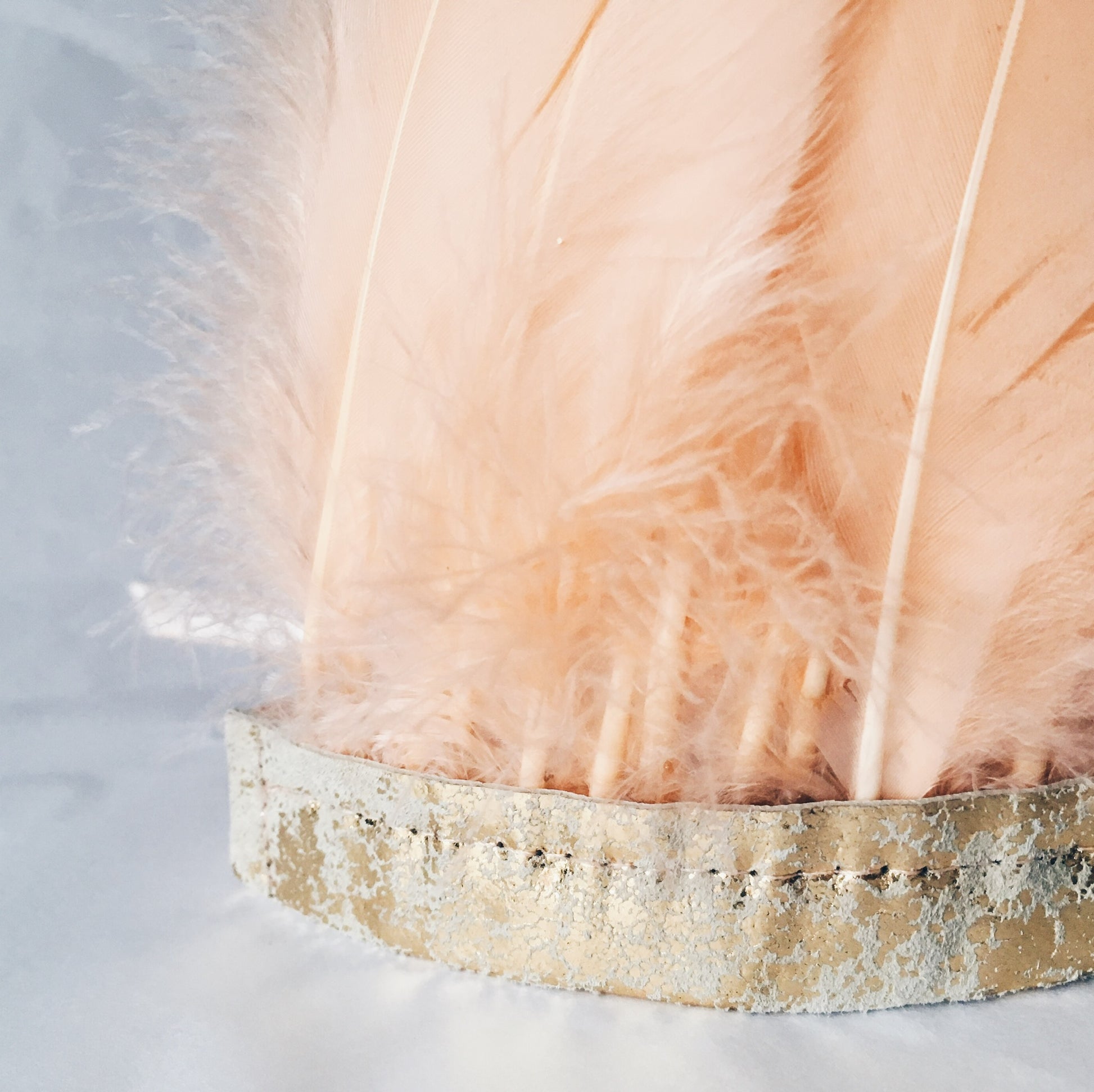 Close up of peach feather and metallic leather headdress by For Just ONE Day
