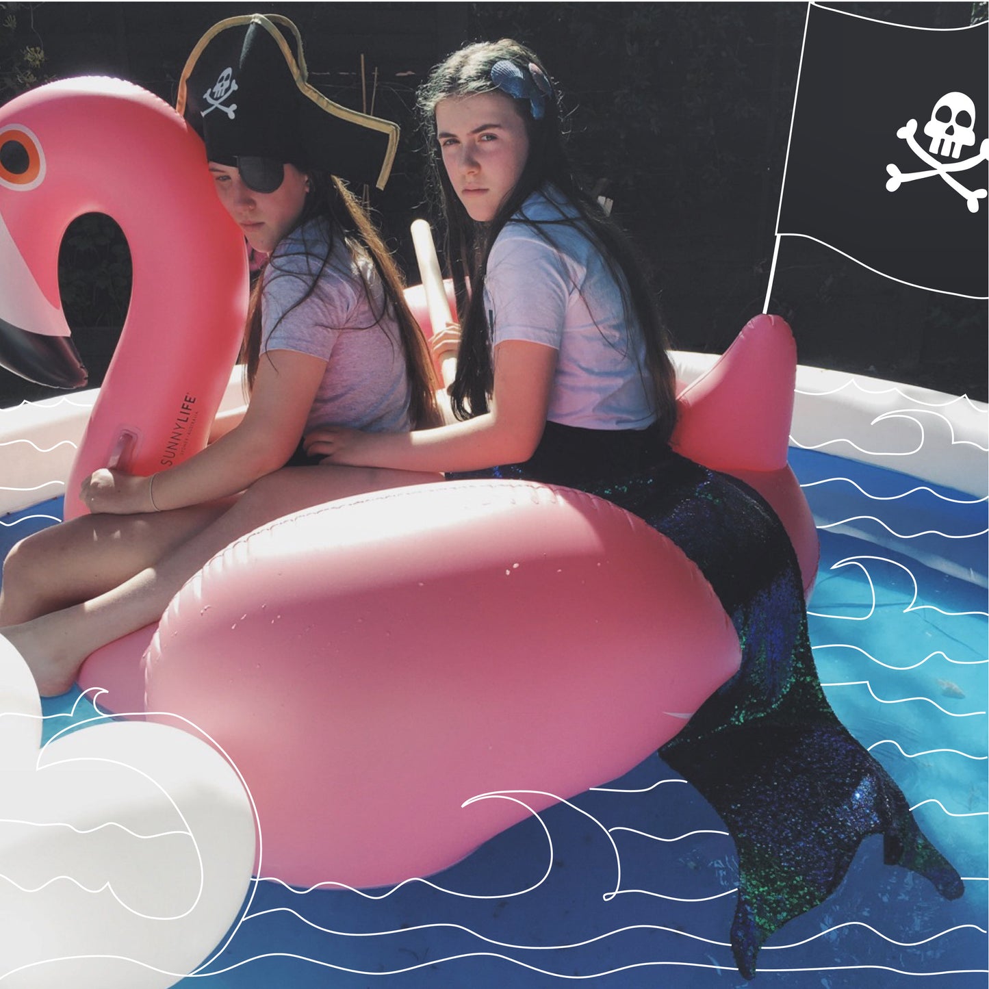 Children wearing a pirate costume and a mermaid costume by For Just ONE Day. Sat on a pink inflatable flamingo 