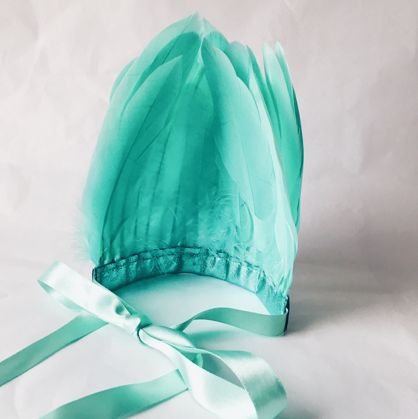 Back view of mint green feather and metallic leather headdress by For Just ONE Day