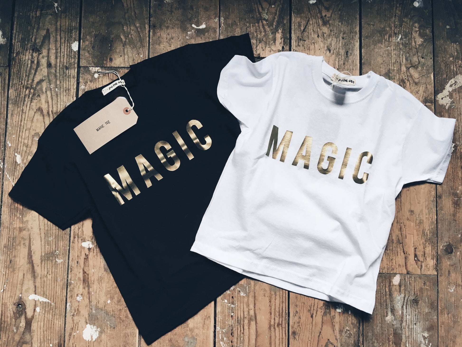 flat-lay on wooden floorboards of Organic Magic t-shirt, in white and black, by For Just ONE Day