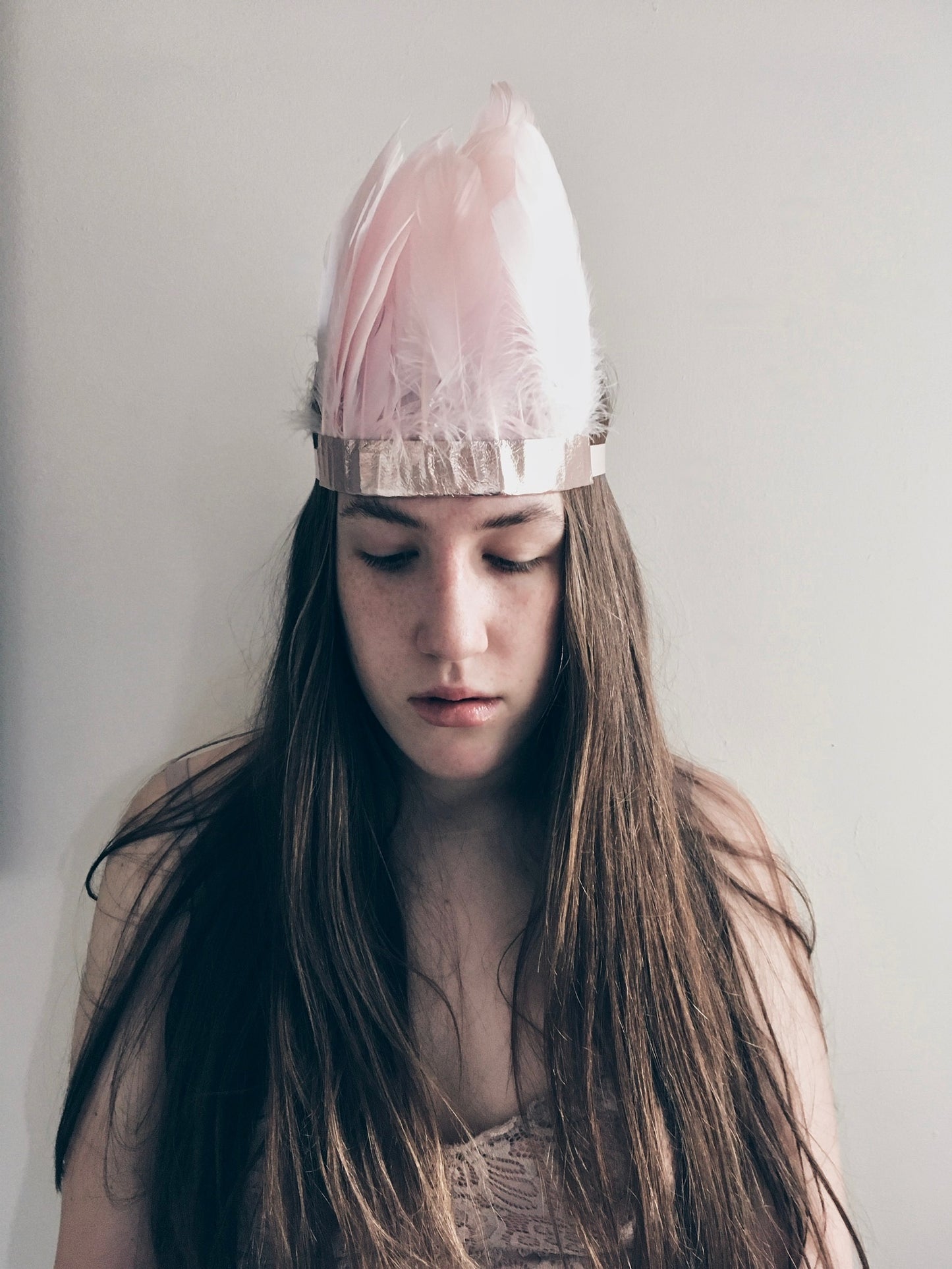 Girl wearing a Pink feather and metallic leather headdress by For Just ONE Day