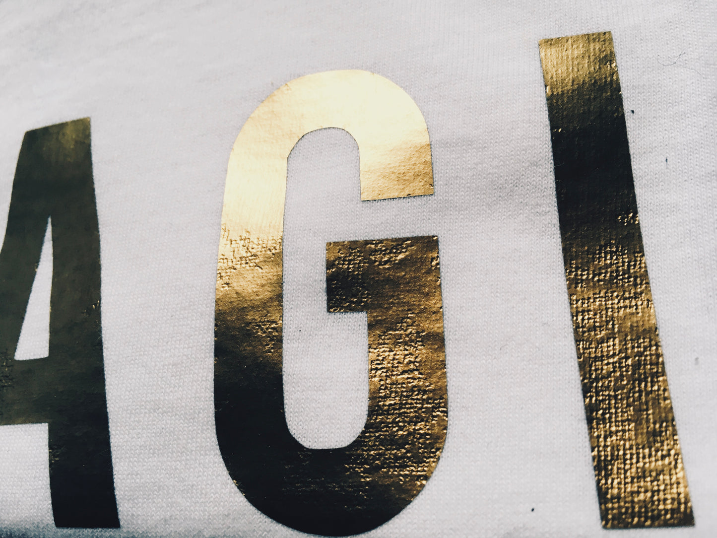 close up of Gold print on white Magic T-shirt
