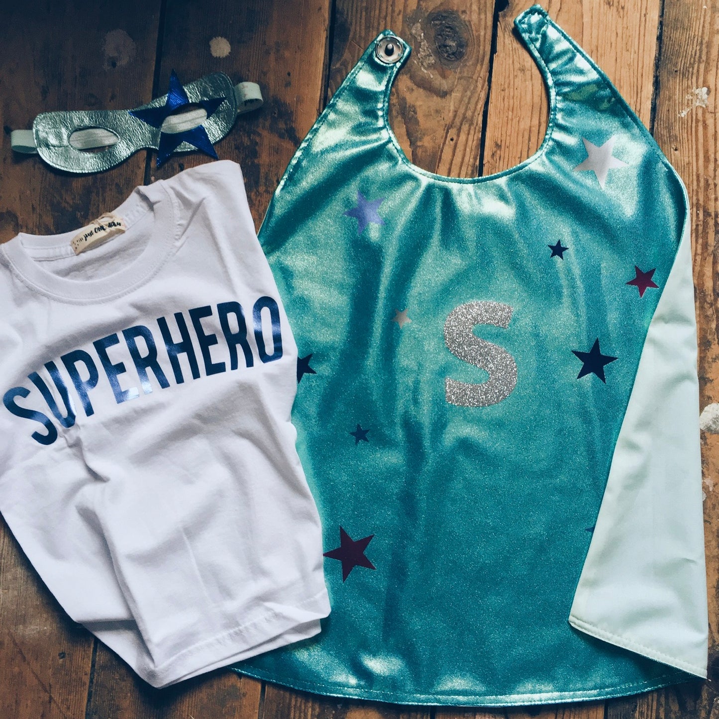 flat-lay of  ice Blue personalised superhero costume by For Just ONE Day - Ice Blue superhero cape, blue superhero T-shirt, Ice Blue star superhero mask