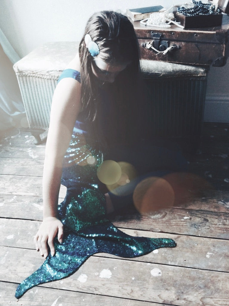 Girl wearing a mermaid costume by For Just ONE Day - green blue sequin mermaid tail , sequin cape, mermaid t-shirt, velvet shorts and shell hair clips