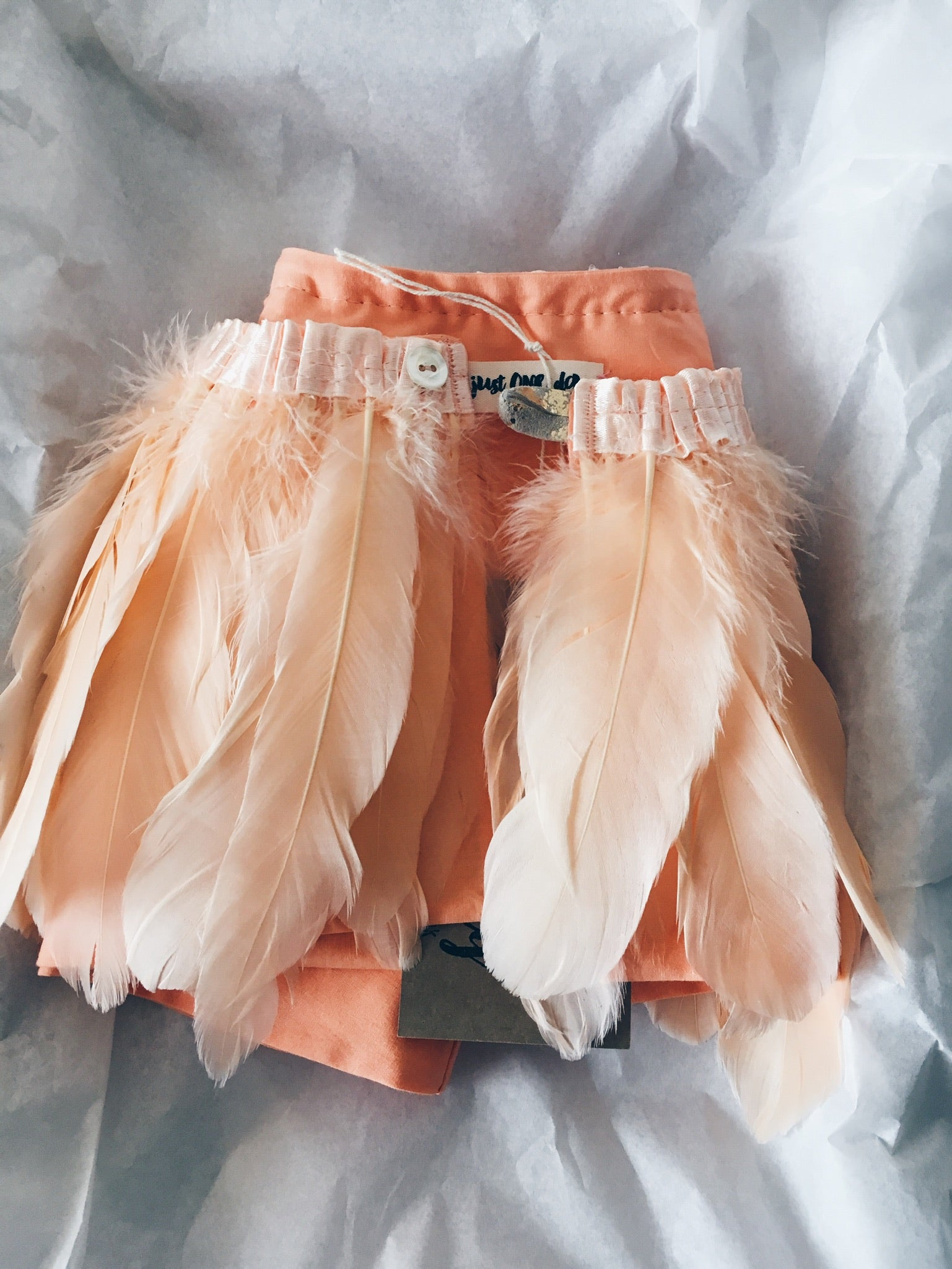 folded peach feather cape
