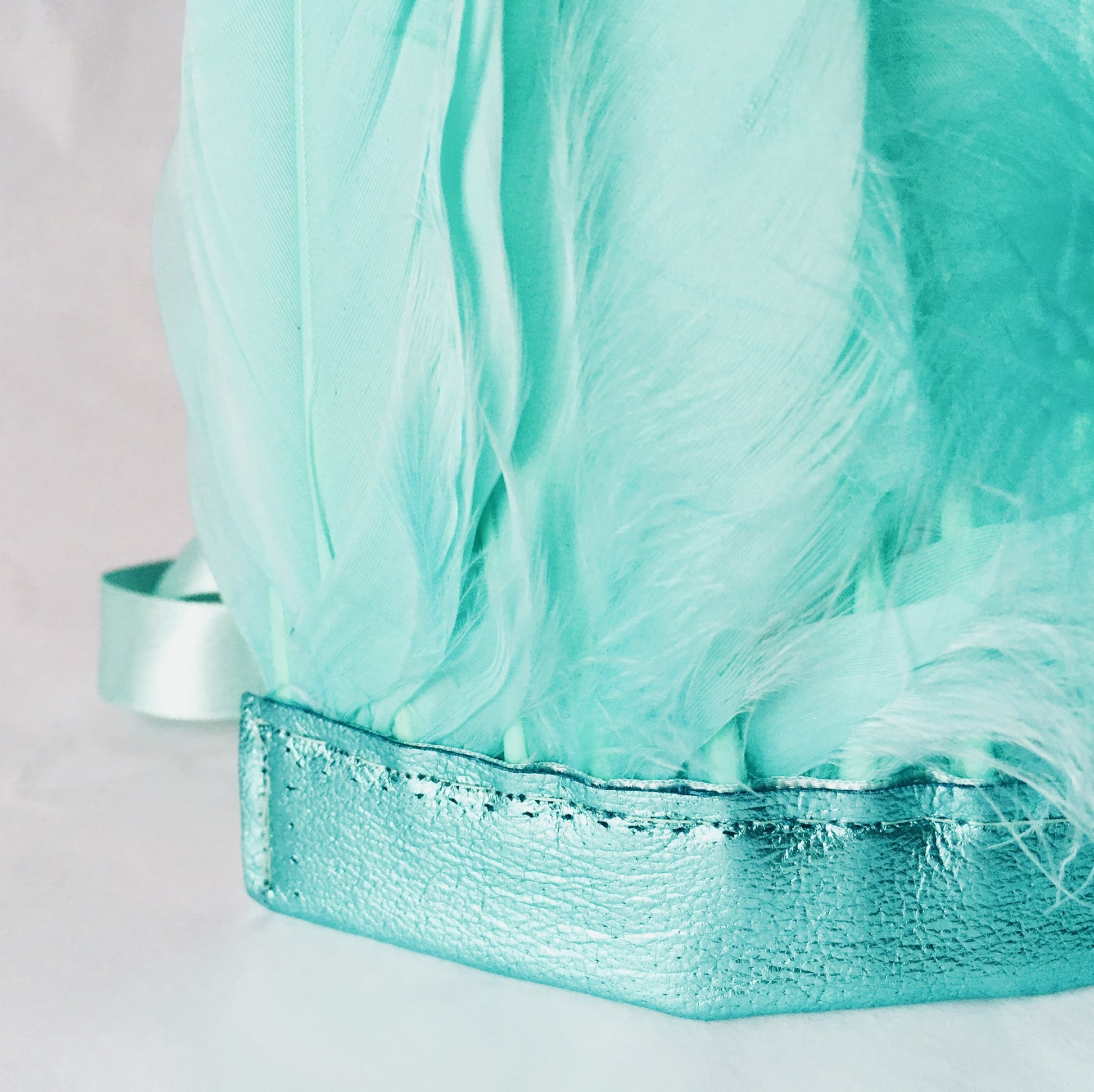 Close-up of mint green feather and metallic leather headdress by For Just ONE Day